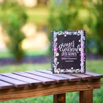 Planner titled 'Prayers & Journal for Women 2026 Planner' on a wooden table with a blurred natural background