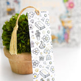 Decorative bookmark with illustrations in front of a blurred floral arrangement