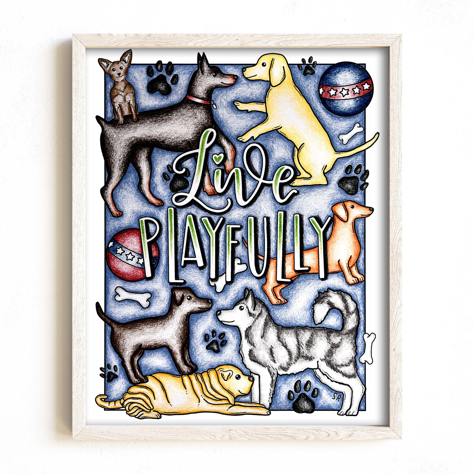 Framed artwork with cartoon dogs and the text 'Live Playfully' on a blue background.