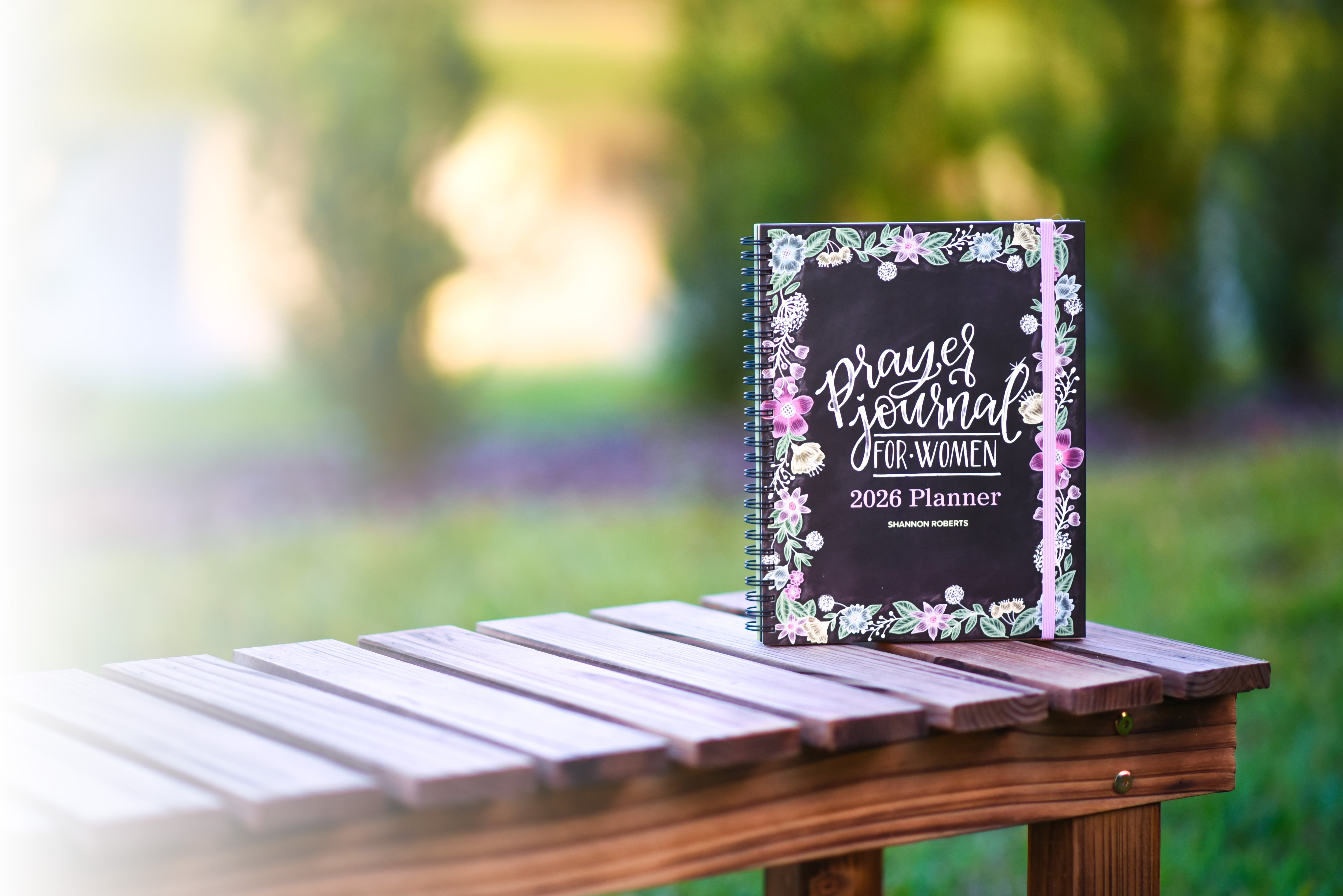 Prayer journal for women planner on a wooden table with a blurred natural background