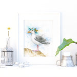 Decorative setup with a seagull painting, vase, and small plant on a white surface.